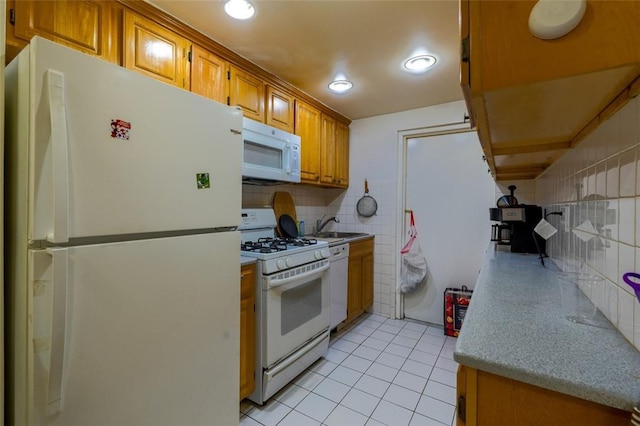 kitchen with sink, light tile patterned floors, white appliances, and decorative backsplash