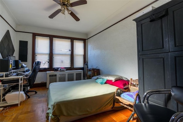 bedroom featuring ceiling fan and dark parquet flooring