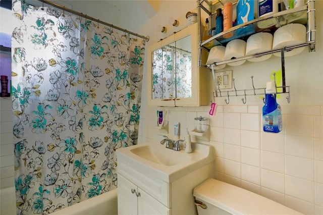 full bathroom with vanity, tile walls, shower / tub combo with curtain, and toilet