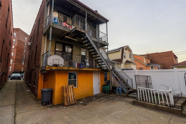 back house at dusk featuring a balcony