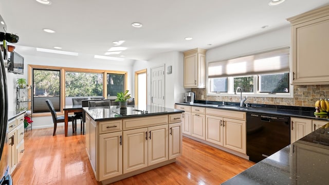 kitchen featuring sink, a center island, black appliances, cream cabinetry, and light wood-type flooring