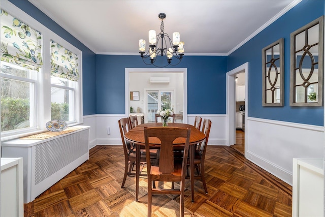 dining space with a notable chandelier, radiator heating unit, dark parquet floors, and ornamental molding