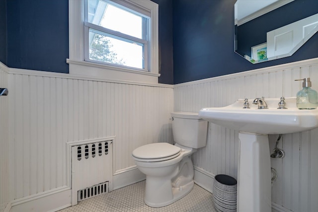 bathroom with radiator, sink, tile patterned floors, and toilet