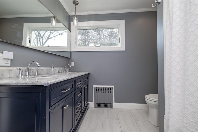 bathroom featuring vanity, radiator, crown molding, and a wealth of natural light