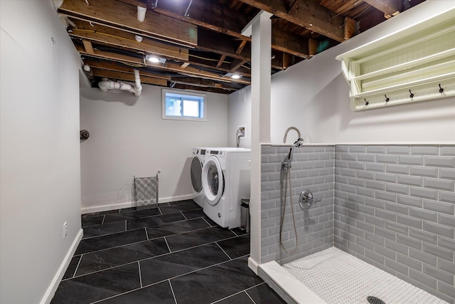 laundry room featuring dark tile patterned floors and washing machine and clothes dryer