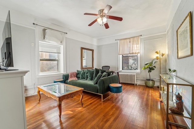 living room featuring radiator, hardwood / wood-style flooring, and ceiling fan