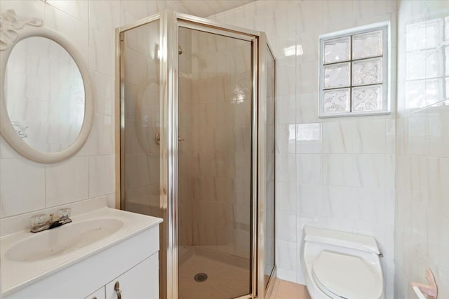 bathroom featuring vanity, a shower with shower door, tile walls, and toilet