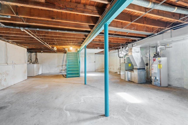 basement featuring washer and dryer, heating unit, and water heater