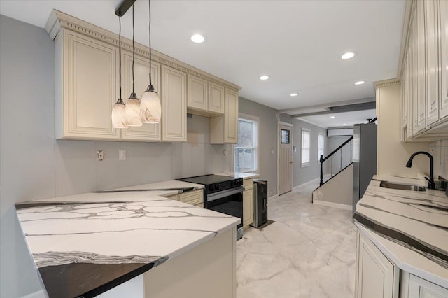 kitchen with sink, decorative light fixtures, black electric range, and cream cabinetry