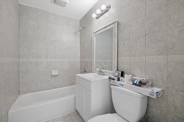 full bathroom featuring toilet, tiled shower / bath, tile walls, vanity, and tile patterned flooring