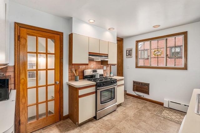 240-25 Alameda Ave, Douglaston, NY 11362 - kitchen featuring under cabinet range hood, a baseboard heating unit, stainless steel gas range oven, decorative backsplash, and heating unit