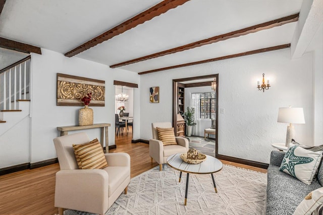 240-25 Alameda Ave, Douglaston, NY 11362 - living area with baseboards, an inviting chandelier, stairs, beam ceiling, and wood finished floors