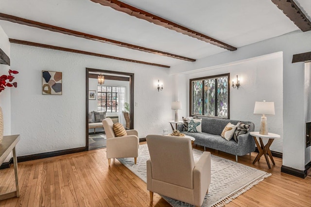 240-25 Alameda Ave, Douglaston, NY 11362 - living area featuring beam ceiling, light wood-style flooring, a textured wall, and baseboards