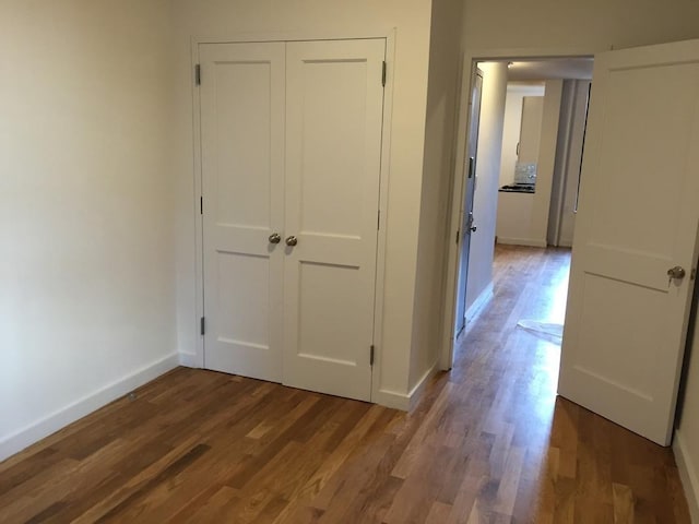 hallway with hardwood / wood-style floors