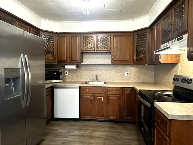 kitchen with tasteful backsplash, sink, dark brown cabinets, and stainless steel appliances