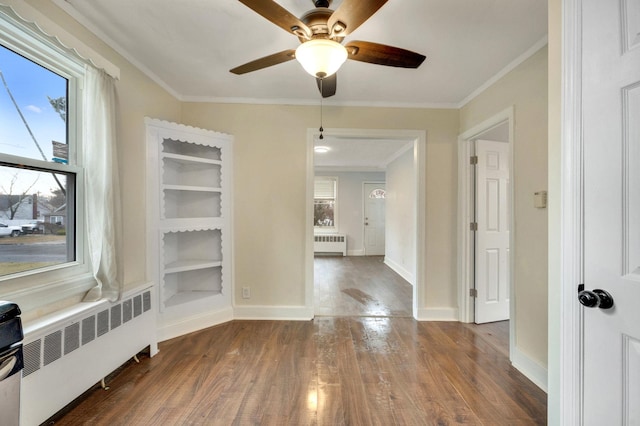 unfurnished living room featuring ornamental molding, dark wood-type flooring, and radiator heating unit