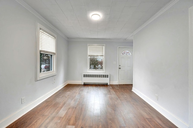 unfurnished room with crown molding, radiator, and hardwood / wood-style floors