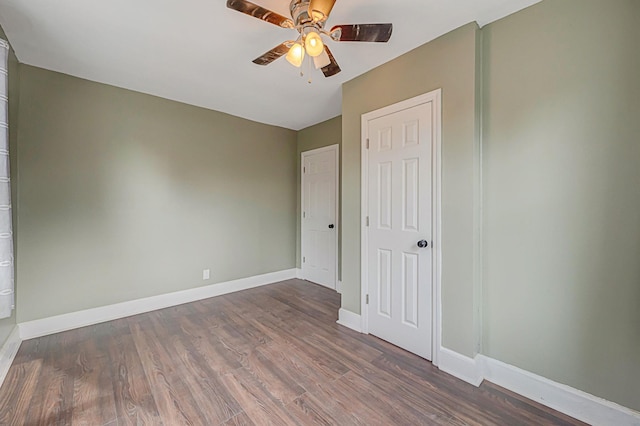 unfurnished bedroom featuring dark wood-type flooring and ceiling fan