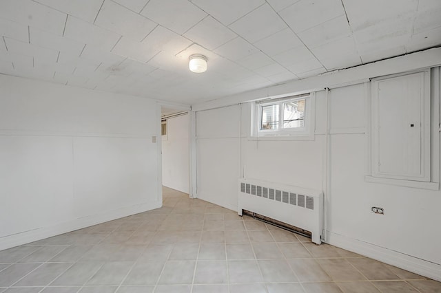 basement featuring electric panel and radiator