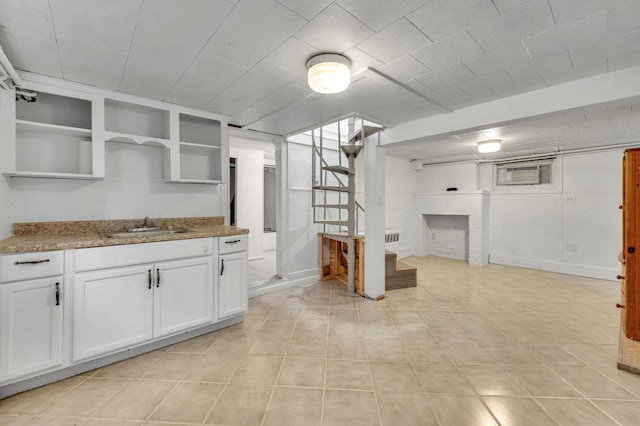 kitchen with white cabinetry, sink, and light stone counters