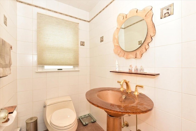 half bathroom featuring tile walls and toilet