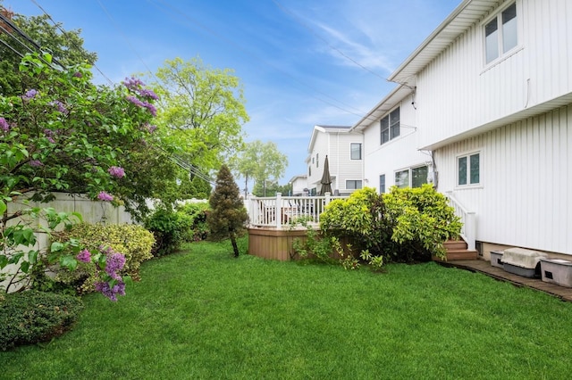 view of grassy yard featuring a deck