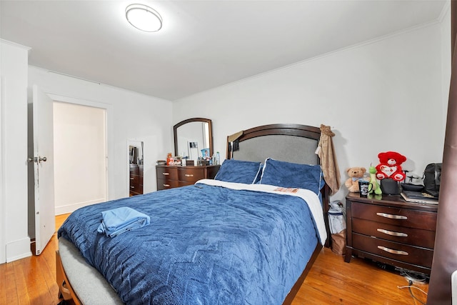 bedroom with wood-type flooring and crown molding