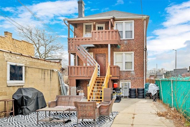 rear view of property with an outdoor living space, a balcony, and a patio area