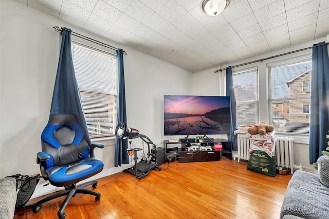 interior space featuring hardwood / wood-style flooring, a healthy amount of sunlight, and radiator heating unit