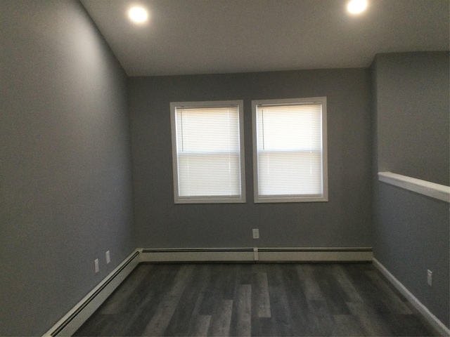 spare room featuring dark hardwood / wood-style flooring and a baseboard radiator