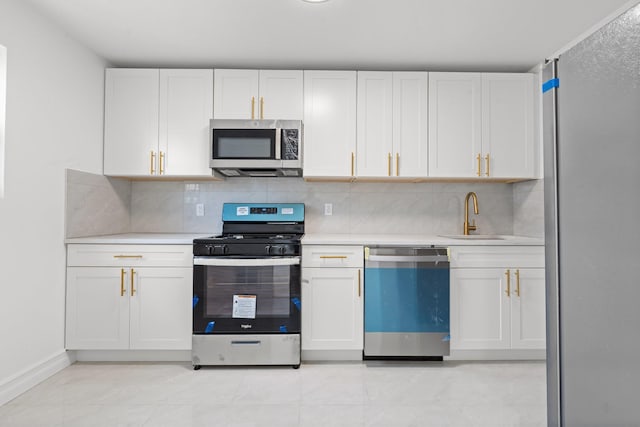 kitchen featuring white cabinetry, stainless steel appliances, sink, and tasteful backsplash