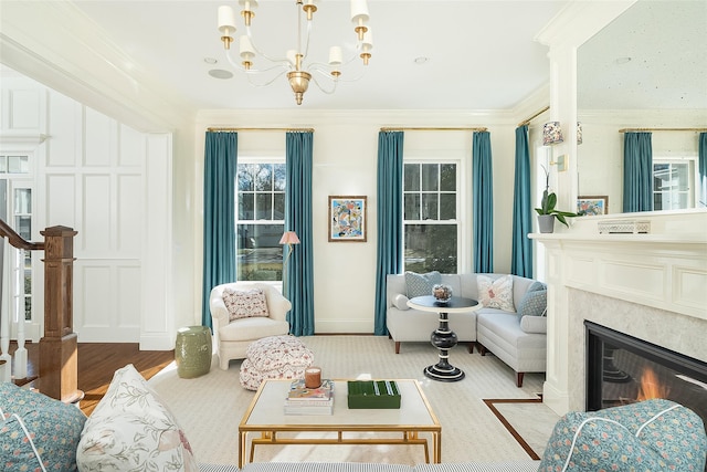 living room featuring an inviting chandelier, ornamental molding, and light hardwood / wood-style floors