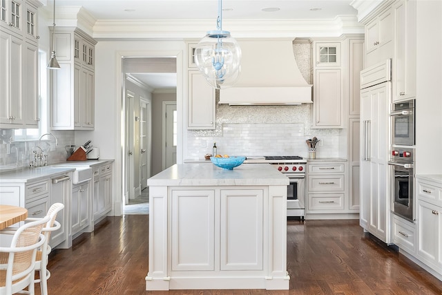 kitchen featuring stainless steel stove, white cabinetry, hanging light fixtures, a kitchen island, and custom exhaust hood