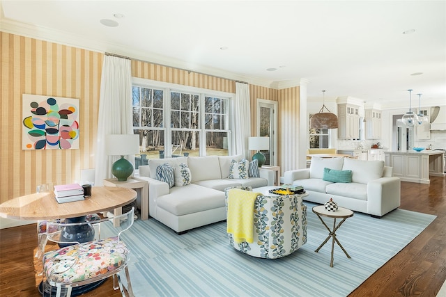 living room with crown molding, light hardwood / wood-style floors, and a healthy amount of sunlight