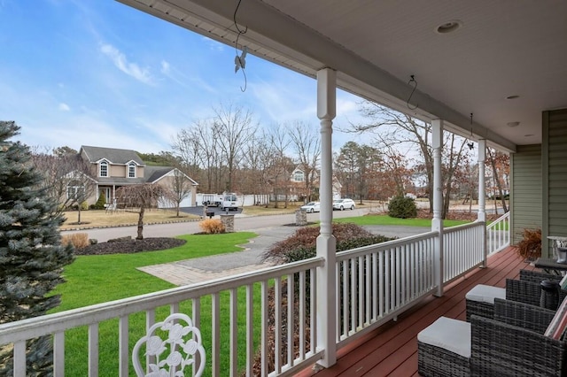 wooden terrace with covered porch and a lawn