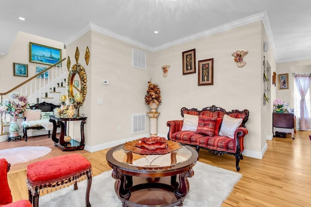 living room featuring crown molding and light hardwood / wood-style flooring