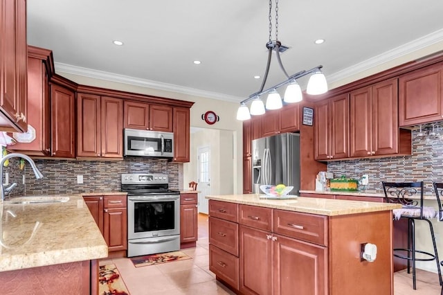 kitchen with sink, crown molding, hanging light fixtures, stainless steel appliances, and a kitchen island