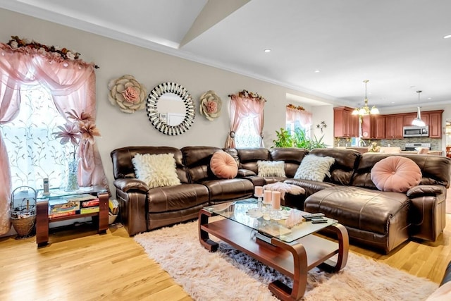 living room featuring crown molding, light hardwood / wood-style flooring, and a wealth of natural light