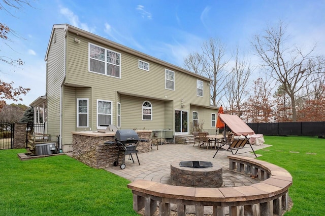 rear view of house featuring a fire pit, an outdoor bar, a yard, a patio area, and area for grilling