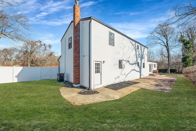 back of house with cooling unit, a lawn, and a patio area