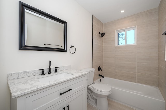 full bathroom with tiled shower / bath, vanity, and toilet