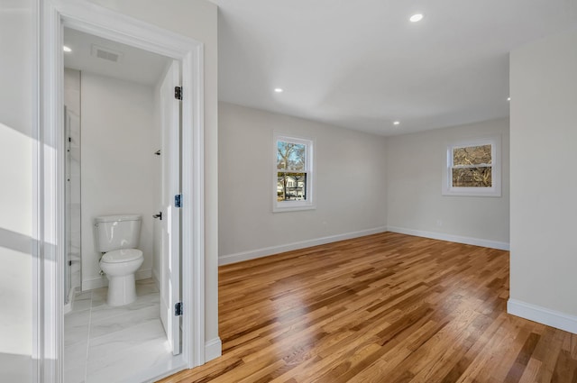 interior space with hardwood / wood-style flooring and toilet