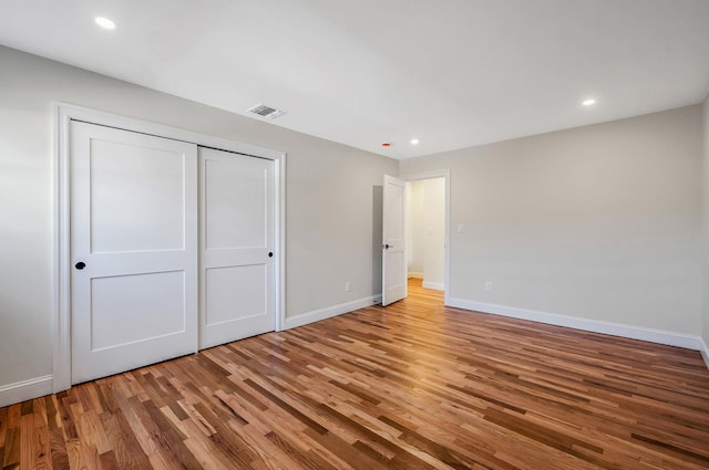 unfurnished bedroom with light hardwood / wood-style flooring and a closet