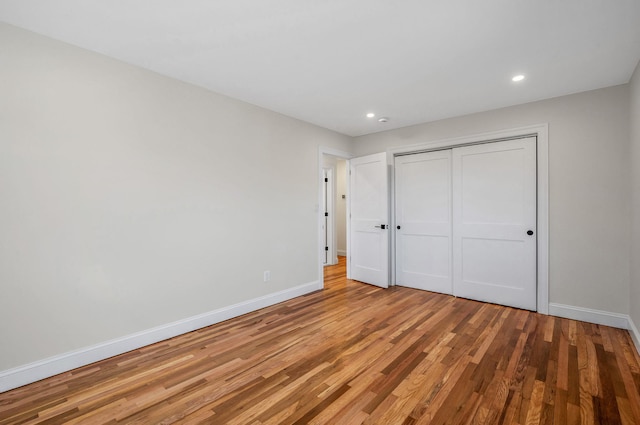 unfurnished bedroom with a closet and light wood-type flooring