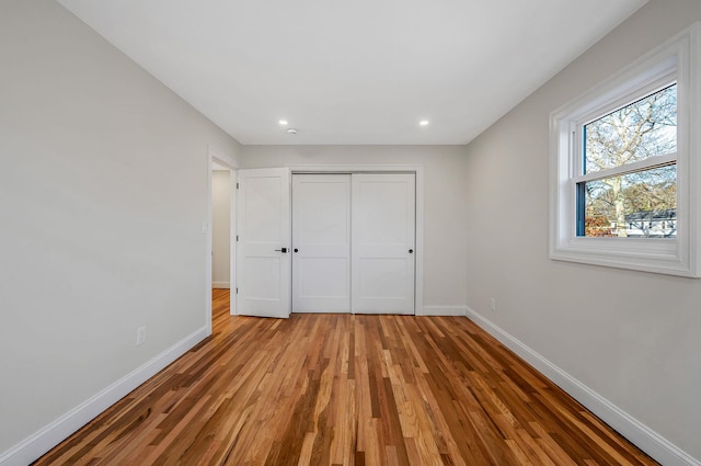 unfurnished bedroom featuring light hardwood / wood-style floors and a closet