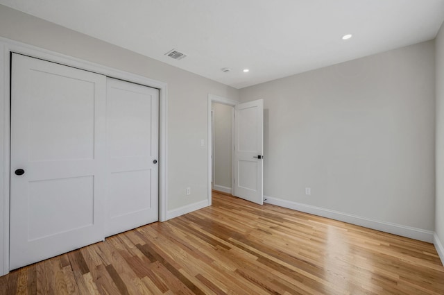 unfurnished bedroom with a closet and light wood-type flooring