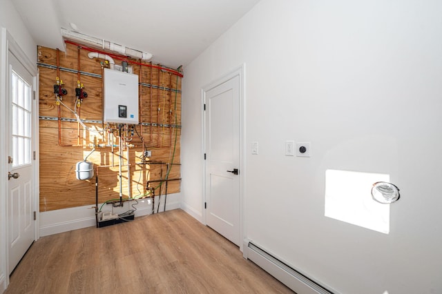 interior space with water heater, wood-type flooring, and baseboard heating