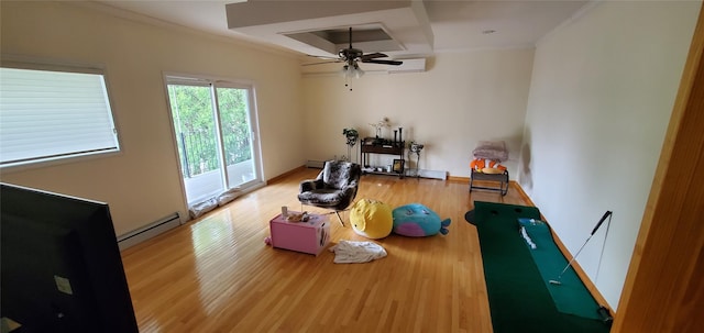 interior space with crown molding, ceiling fan, hardwood / wood-style floors, and a baseboard heating unit