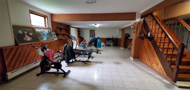 exercise room featuring a baseboard radiator and wood walls