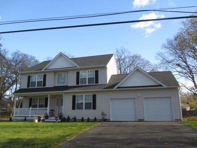 view of front of home featuring a garage, a front lawn, and covered porch